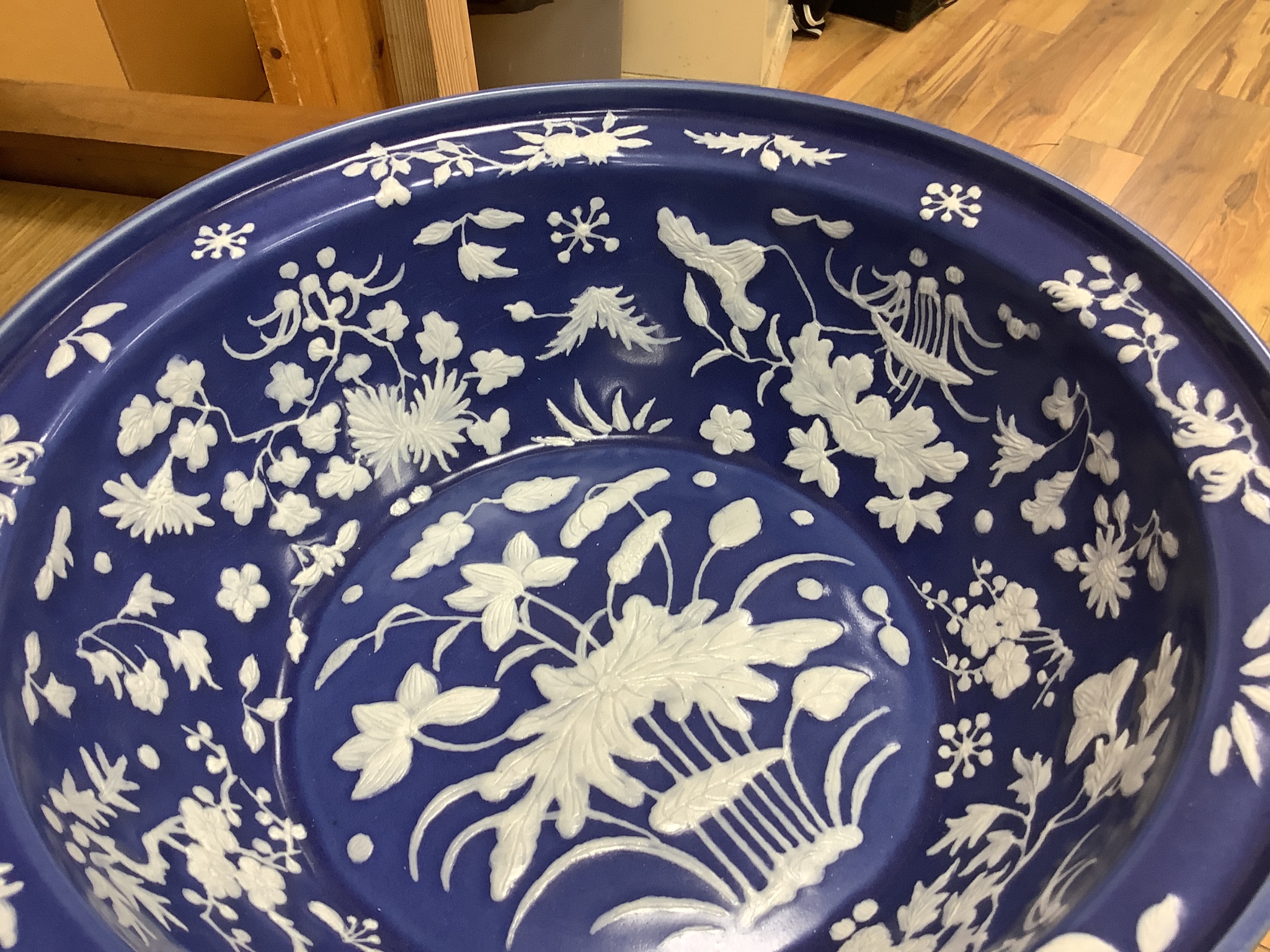 A large Chinese blue and white porcelain basin, lightly relief moulded with plants, 40cm